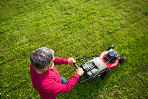 Senior man maaien zijn tuin - shot van bovenaf — Stockfoto
