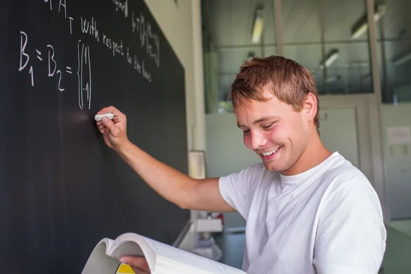 Guapo estudiante universitario resolviendo un problema de matemáticas — Foto de Stock