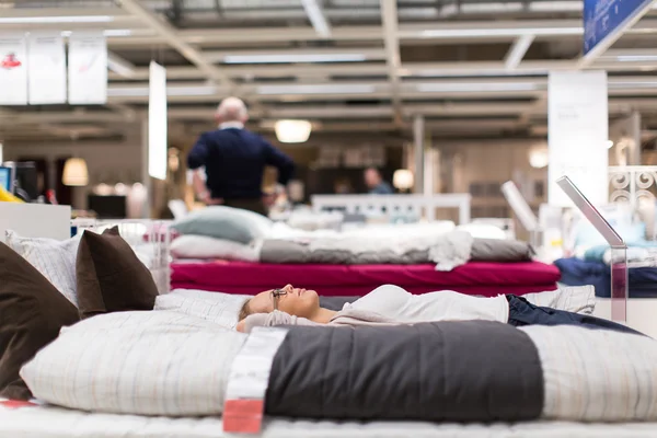 Pretty, young woman choosing the right bed/mattrase — Stock Photo, Image