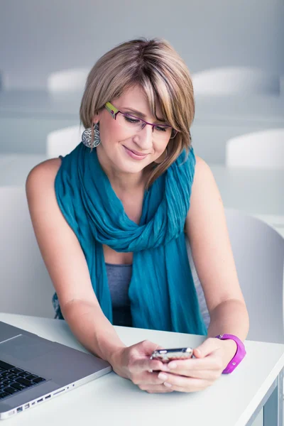 Жінка використовує ноутбук і свій смартфон — стокове фото
