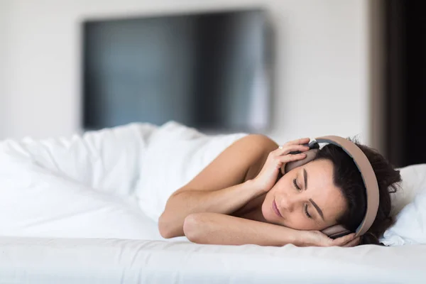 Güzel Genç Bir Kadın Yatakta Müzik Dinliyor Kulaklıklarıyla Dinleniyor — Stok fotoğraf