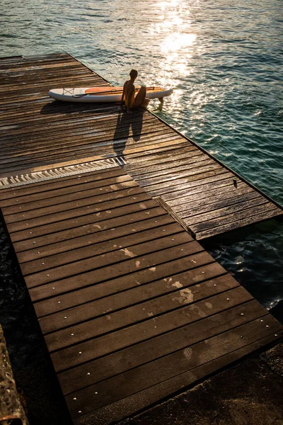 Sup站起来划桨板的概念 美丽的年轻女子在傍晚温暖的阳光下划桨在一个可爱的湖上 — 图库照片