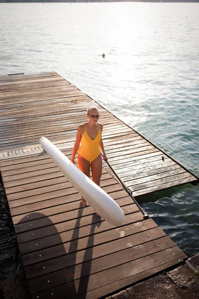 Sup站起来划桨板的概念 美丽的年轻女子在傍晚温暖的阳光下划桨在一个可爱的湖上 — 图库照片