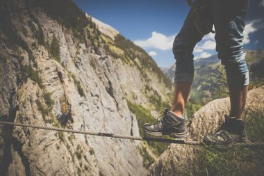 Demir bir iple yürüyen ferrata 'lı bir adam. Kandersteg İsviçre 'nin İsviçre Alpleri' nde inanılmaz bir tatil yeri.