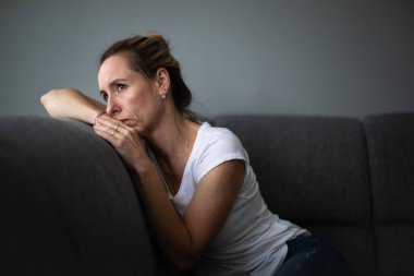 Depresyondaki orta yaşlı kadın evde üzgün, yalnız, endişeli (renkli tonlu görüntü))