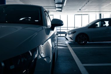 Yeraltı otoparkı. Garajda hiç insan olmayan arabalar. Otoparkın içinde bir sürü araba var. Otomobilli yeraltı otoparkı (renk tonlu resim)