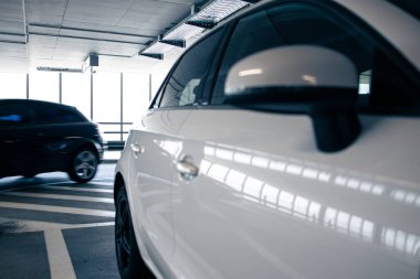 Yeraltı otoparkı. Garajda hiç insan olmayan arabalar. Otoparkın içinde bir sürü araba var. Otomobilli yeraltı otoparkı (renk tonlu resim)