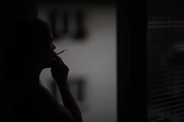 Vrouw Van Middelbare Leeftijd Die Thuis Een Sigaret Opsteekt Haar — Stockfoto