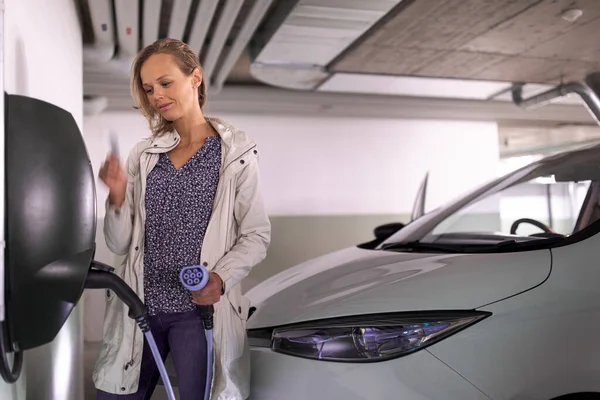 Young Woman Charging Electric Vehicle Underground Garage Equiped Car Charger — Stock Photo, Image