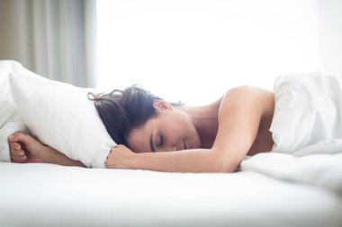 Yatakta uyuyan güzel genç kadın.
