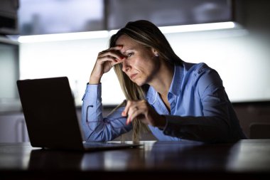 Güzel, orta yaşlı bir kadın gece geç saatlere kadar evde dizüstü bilgisayarla çalışıyor, evden bir iş yürütüyor, uzaktan çalışıyor, hayal kırıklığına uğruyor, tükeniyor.