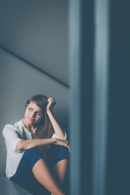 Depresyonda olan genç bir kadın merdivende oturuyor. Coronavirüs salgını yüzünden Jobloss, Covid-19 salgını. İşsizlik, ekonomik kriz, mali sıkıntı kavramı