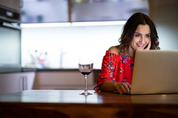 Pretty, mid-aged woman having a virtual Wine Tasting Dinner Event Online Using Laptop with friends