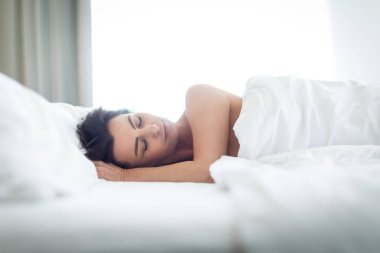 Yatakta uyuyan güzel genç kadın.