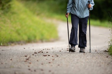 Son sınıf öğrencisi günlük kardiyo egzersizi yaparak formda kalıyor. Bastonla hızlı bir yürüyüş yapıyor.