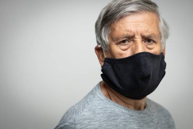 Koronavirüs ve grip salgını sırasında maske takan kıdemli bir adam. Virüs ve hastalık koruması, ev karantinası. COVID-19 kavramı