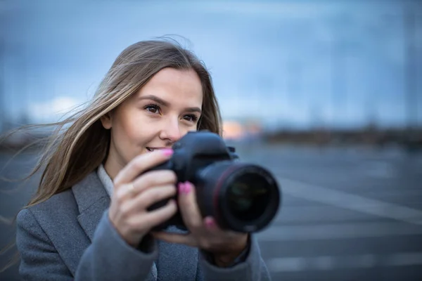 漂亮的年轻女子用专业的飞镖相机拍照 — 图库照片