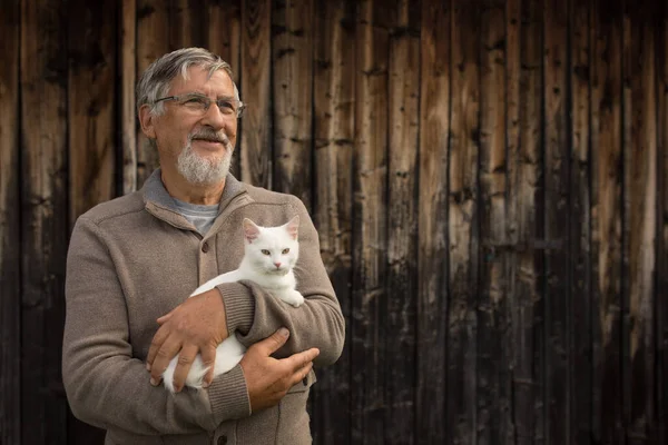 Äldre Man Håller Söt Vit Kattunge Och Ler Mot Kameran — Stockfoto