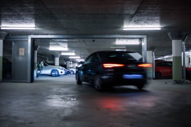 Yeraltı otoparkı. Garajda hiç insan olmayan arabalar. Otoparkın içinde bir sürü araba var. Otomobilli yeraltı otoparkı (renk tonlu resim)