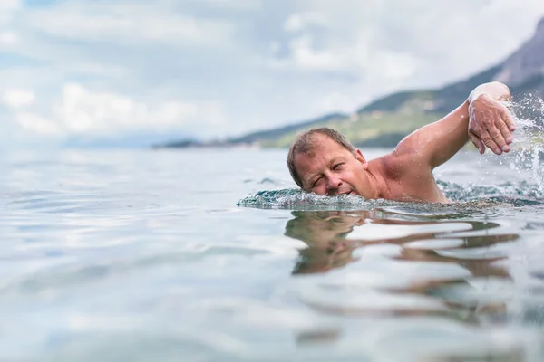 Homme âgé nageant dans la mer ou l'océan — Photo