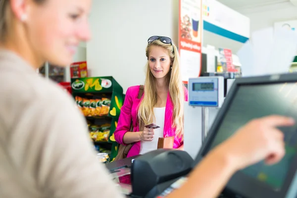 Kvinnan betalar för hennes dagligvaror女性は彼女の食料品の支払い — ストック写真