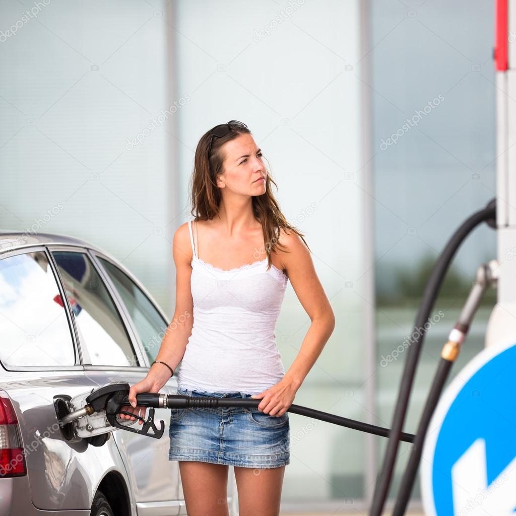Woman refueling her car in a gas station