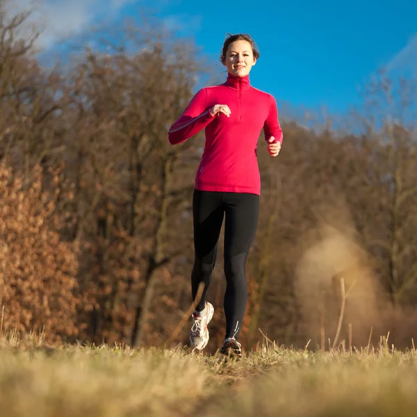 Junge Frau läuft bei kaltem Herbst im Stadtpark ins Freie — Stockfoto