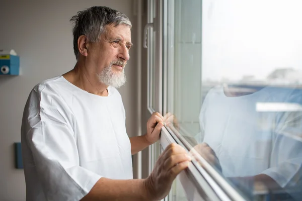 Paciente en un hospital, mirando desde una ventana de su habitación —  Fotos de Stock