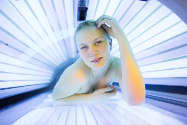 Femme bronzant sa peau dans un solarium moderne — Photo