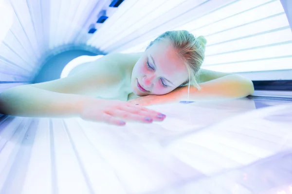 Kvinnan garvning hennes hud i ett modernt solarium — Stockfoto