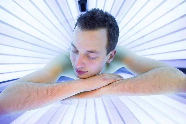 Man relaxing during a tanning session