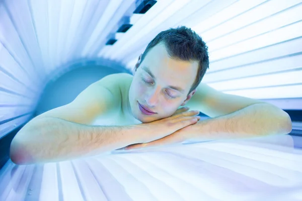 Homme relaxant pendant une séance de bronzage — Photo