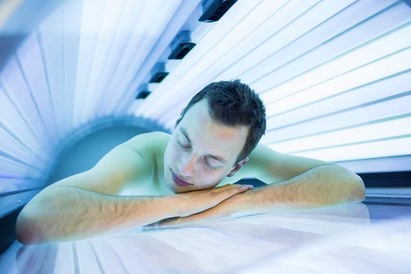 Man relaxing during a tanning session