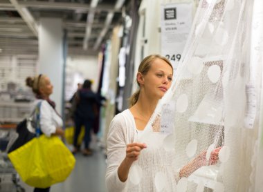 woman choosing the right curtains for her apartmen