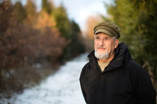 Uomo anziano, all'aperto su un sentiero forestale innevato — Foto Stock