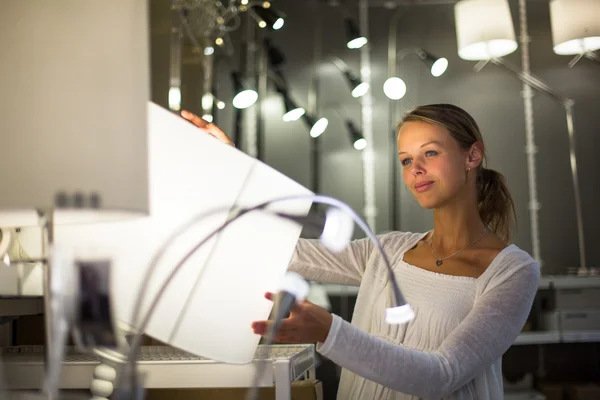 Kvinnan att välja rätt ljus för sin lägenhet — Stockfoto