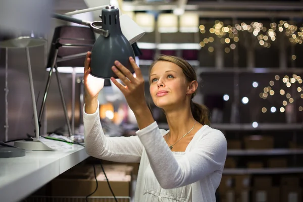 Mujer eligiendo la lámpara adecuada para su apartamento — Foto de Stock