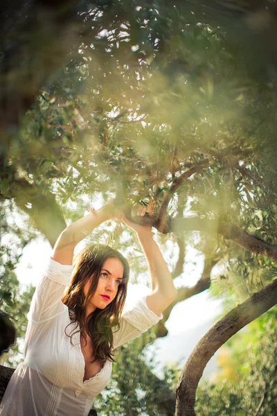 Brunette on the beach, amid olive trees — Stock Photo, Image