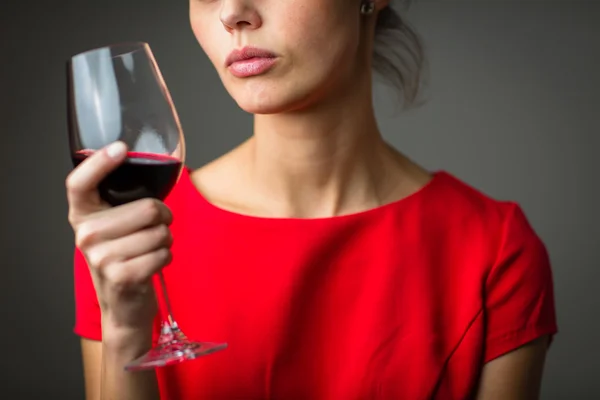 Frau in rotem Kleid bei einem Glas Rotwein — Stockfoto