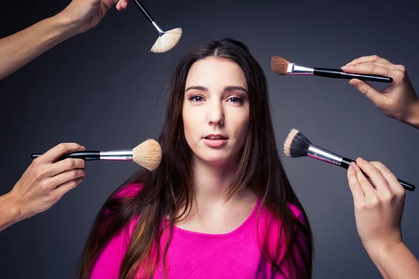Kvinna i den kompetent vård av professionella make-up artister — Stockfoto