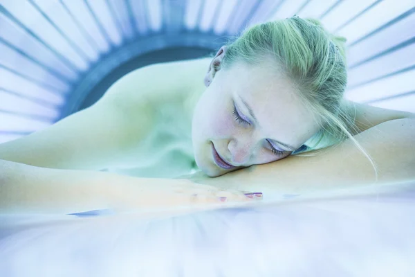 Donna che abbronza la pelle in un moderno solarium — Foto Stock