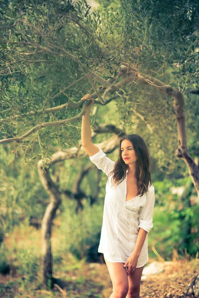 Brunette woman on the beach, amid olive trees — Stock Photo, Image