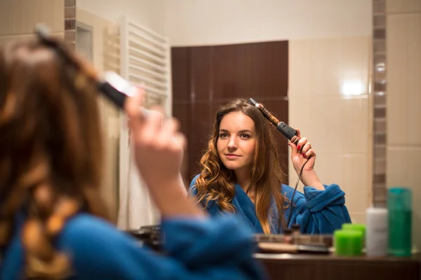 Donna arricciando i capelli — Foto Stock