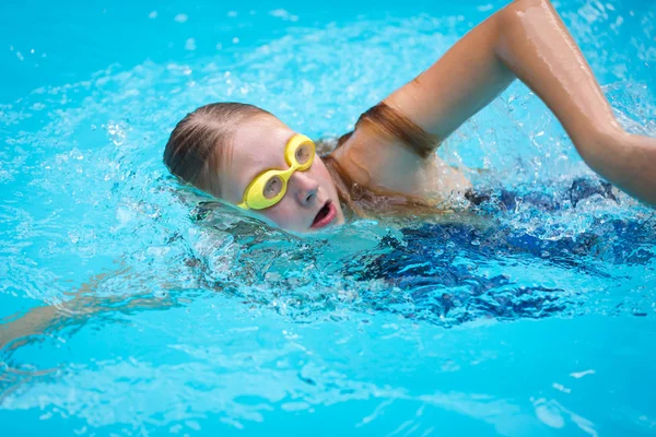 女孩在护目镜和帽游泳爬泳 — 图库照片