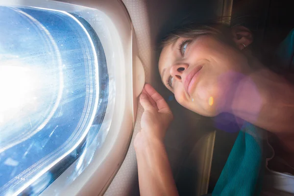 Female airplane passenger enjoying the view from the cabin — Stock Photo, Image