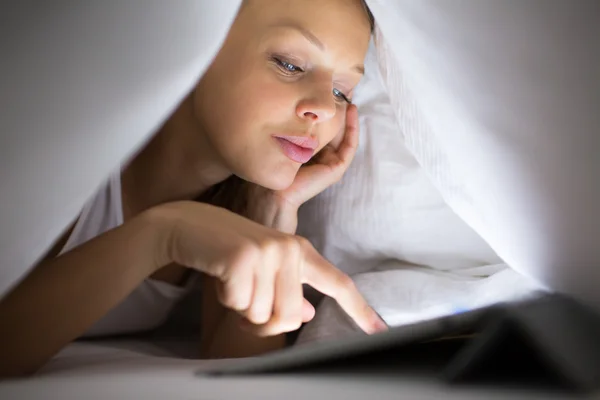 Γυναίκα, χρησιμοποιώντας τον υπολογιστή tablet στο κρεβάτι — Φωτογραφία Αρχείου