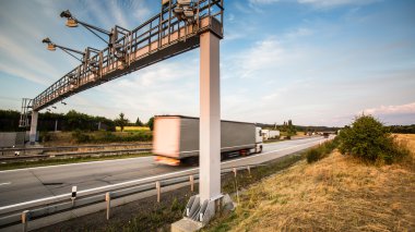 Truck passing through a toll gate on a highway clipart