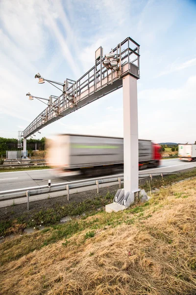 Vrachtwagen passeren een tol-poort op een snelweg — Stockfoto