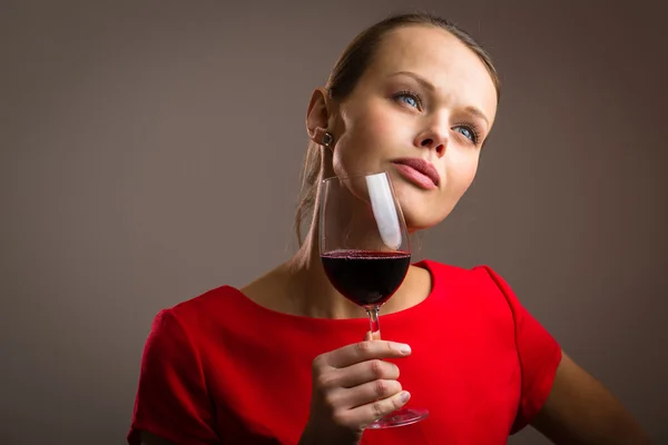 Frau in rotem Kleid bei einem Glas Rotwein — Stockfoto