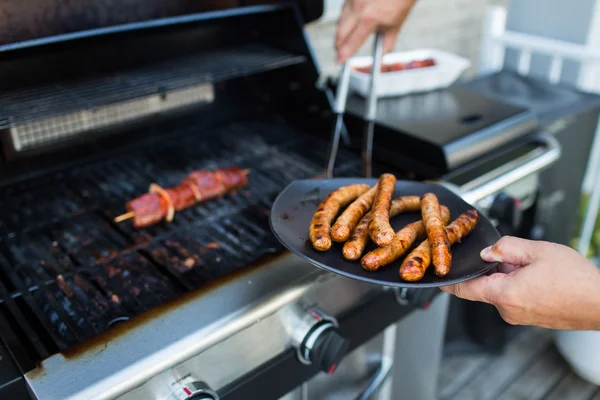 BBQ met worsten en rood vlees op de grill — Stockfoto